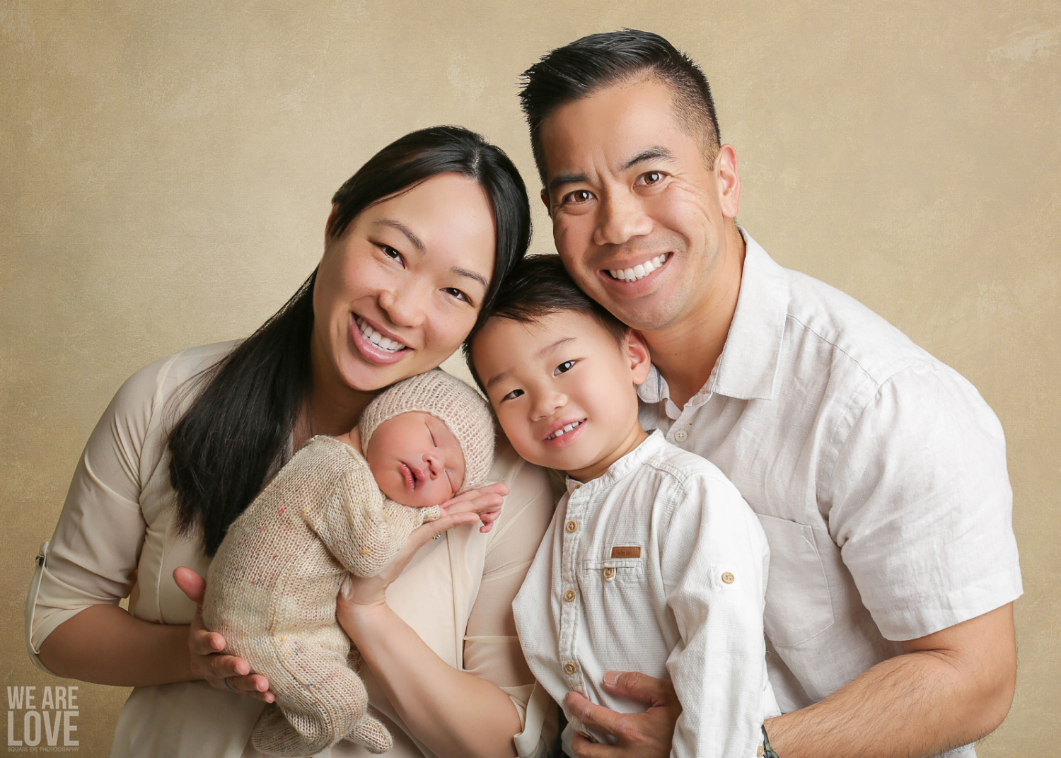 family portrait with tan background of newborn family vietnamese